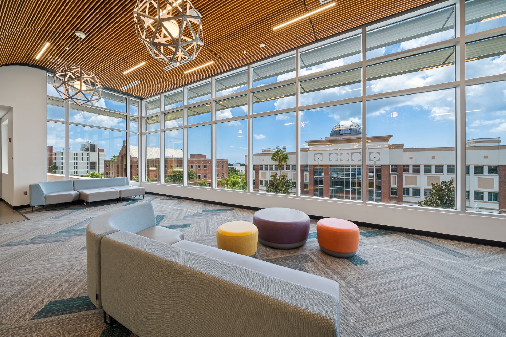 Lobby with couches and stools, view towards a large window